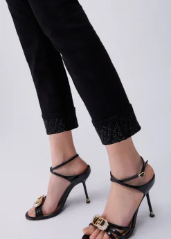Pantaloni skinny con risvolto e strass